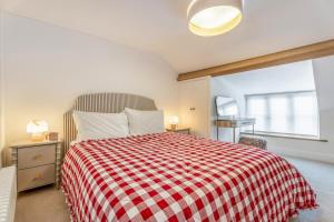a bedroom with a bed with a red and white checked blanket at 2 Bed in Helmsley oc-p36613 in Helmsley