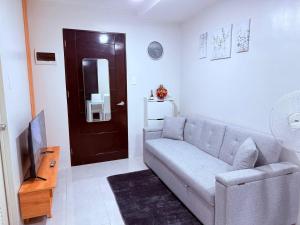 a living room with a couch and a brown door at Vernes Homestay in Mandaue City
