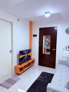 a living room with a couch and a flat screen tv at Vernes Homestay in Mandaue City +4 photos