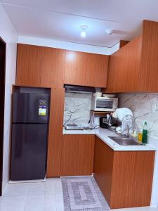 a kitchen with a black refrigerator and a sink at Vernes Homestay in Mandaue City