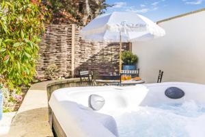 a hot tub with an umbrella next to a patio at 2 Bed in Helmsley oc-p36613 in Helmsley