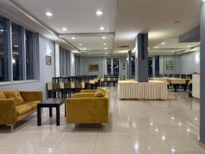 a lobby with couches and tables and a dining room at Hotel Martin in Međugorje