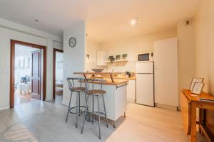 a kitchen with a counter and stools in a room at Le Sebastopol - Appt moderne de 65m2 in Strasbourg