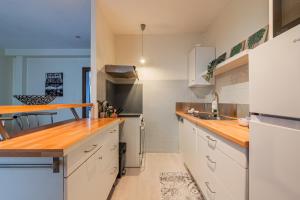 a kitchen with white cabinets and wooden counter tops at Le Sebastopol - Appt moderne de 65m2 in Strasbourg +2 photos