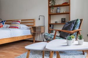 a bedroom with a bed and a chair and a table at Le Sebastopol - Appt moderne de 65m2 in Strasbourg