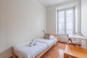 a room with a bed and a desk and a window at Le Sebastopol - Appt moderne de 65m2 in Strasbourg