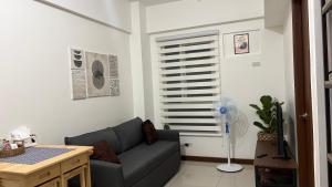 a living room with a couch and a fan at Peppers Crib in Manila +8 photos