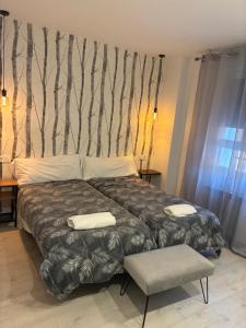 a bedroom with a bed with a tree mural on the wall at Apartamento en Mansilla in Mansilla de las Mulas