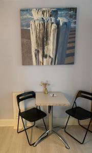 a table with two chairs and a painting on the wall at Logies La Dune Westende-Bad - Gratis parking in Middelkerke