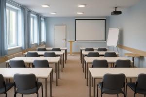 an empty classroom with tables and chairs and a whiteboard at Vlčí důl Bludov in Bludov