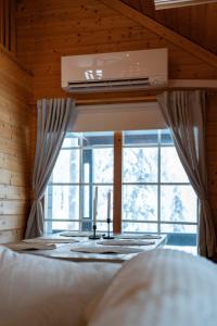 a bedroom with a bed and a window with two candles at Syötekätkö in Syöte