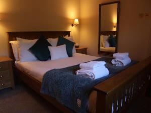ein Schlafzimmer mit einem Bett, auf dem Handtücher liegen in der Unterkunft Stunning New Forest Country House - Abbot's Well for up to 10 guests in Godshill