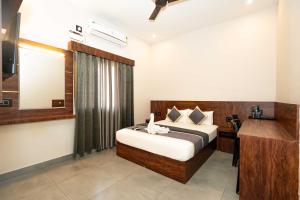 a bedroom with a bed with a desk and a mirror at Hotel ELITE Rameswaram in Rāmeswaram