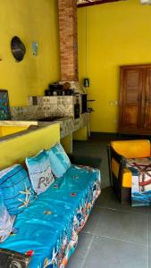 a room with a bed and a table and a yellow wall at Solar Paraty - Casa perto do centro com psicina in Paraty +24 photos