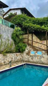 a swimming pool in front of a house at Solar Paraty - Casa perto do centro com psicina in Paraty