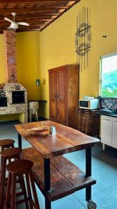 a kitchen with a wooden table and stools at Solar Paraty - Casa perto do centro com psicina in Paraty