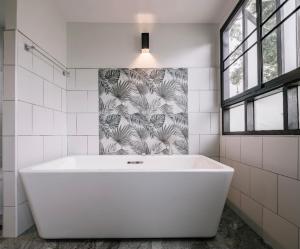 a large white bath tub in a bathroom with a window at Palin Family Cottage in Chiang Rai +49 photos