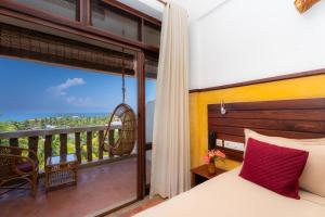 a bedroom with a bed and a balcony at DrUnni's Ayurveda Resort in Kovalam