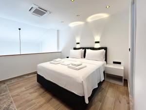 a white bedroom with a large bed with white sheets at MY Sunset Suite in Kuşadası +19 photos