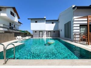 a swimming pool in front of a building at MY Sunset Suite in Kuşadası