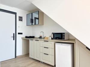 a kitchen with a counter with a microwave and a refrigerator at MY Sunset Suite in Kuşadası