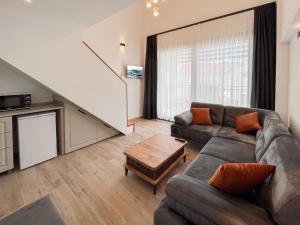 a living room with a couch and a table at MY Sunset Suite in Kuşadası
