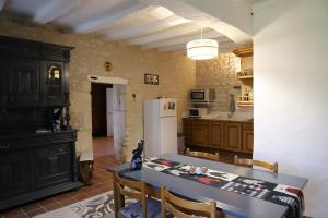 a kitchen with a table and a white refrigerator at Au repos des elfes in Braye-sous-Faye