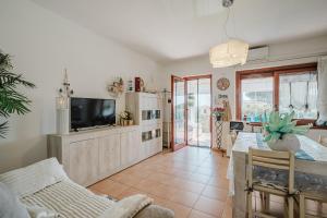 a living room with a tv and a table at villetta giulia fronte mare in Stintino