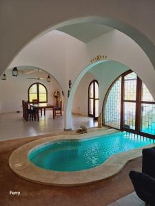 a large swimming pool with an archway in a house at Executive One bedroom with extra mattress 02 in Mombasa