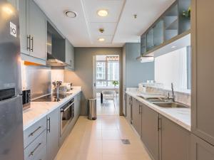 a large kitchen with white cabinets and a large sink at the 'New York' Condo - 4BR Executive Burj Khalifa Suite in Dubai