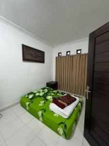 a bedroom with a green bed in a room at laksana homestay in Cireungit