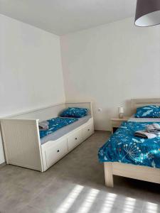 two beds in a white room with blue sheets at Apartmán U Štýbnarů in Bulhary +3 photos