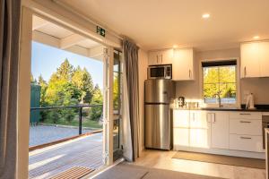 a kitchen with a sliding glass door leading to a balcony at The Dales in Twizel