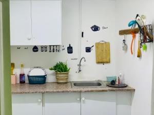 a kitchen with white cabinets and a sink at Rooms & Suites Western Dhafra Housing in Ghayathi