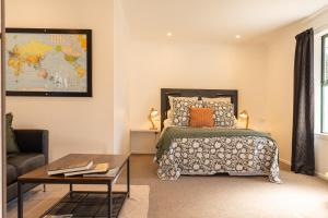 a bedroom with a bed and a couch and a table at The Dales in Twizel