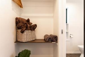 a bathroom with a basket of towels on a shelf at The Dales in Twizel +28 photos