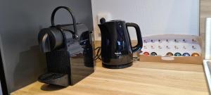 a black coffee maker sitting on a counter with a box at Het Wellnesstje in Teuge
