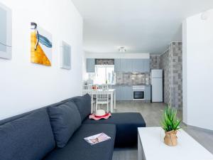 a living room with a blue couch and a kitchen at Atico Vega Penthouse in Adeje