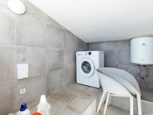 a laundry room with a washing machine and a chair at Atico Vega Penthouse in Adeje