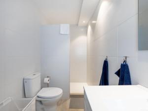 a white bathroom with a toilet and a sink at Atico Vega Penthouse in Adeje +25 photos