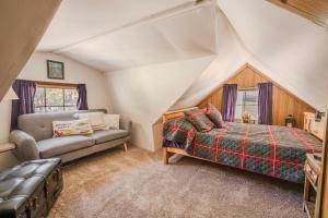 a bedroom with a bed and a couch in a attic at Gonzalez Cabin in Running Springs