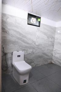 a bathroom with a toilet and a picture on the wall at Rio Casa Homestay in Cochin