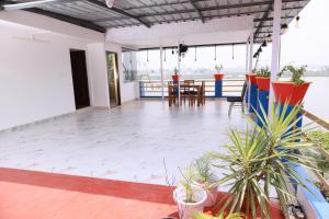 a room with a table and chairs and plants at Rio Casa Homestay in Cochin +2 photos