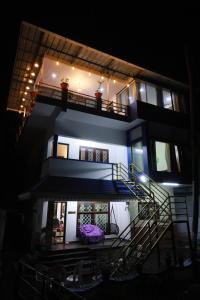 a building with a staircase and a balcony at night at Rio Casa Homestay in Cochin