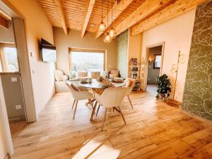 a dining room and living room with a table and chairs at Schäfers - Ihr Wohlfühlort, Ferienwohnungen & Ferienhaus am Naturteich an 2 Seen bei Leipzig in Großpösna +59 photos