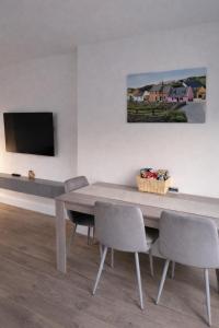 a dining room with a wooden table and chairs at Aran View Holiday Homes - The Courtyard Suite - Cozy for two in Doolin