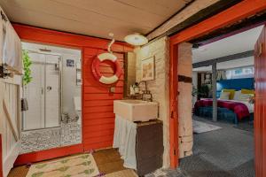a bathroom with a sink and a red wall at One Drake Road Hotel in Tavistock