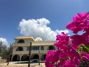 a building with pink flowers in front of it at Executive One bedroom with extra mattress 02 in Mombasa