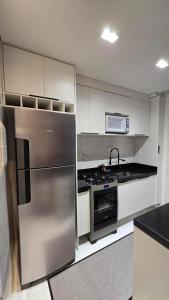 a kitchen with a stainless steel refrigerator and a stove at Belo Apartamento Com Piscina in Várzea Grande +16 photos