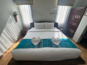 a bedroom with a bed with two hearts on it at PhuKasa Valley Maesot -Wellness Resort in Ban Mae Kasa
